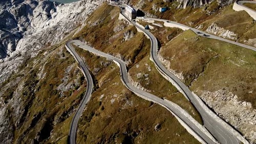 Aerial flyover over Furka mountain pass at the border of Valais and Uri in Switzerland with a pan up