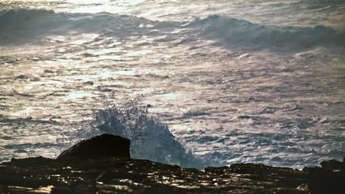 Ocean Waves Crashing on Rocky Shore at Sunset