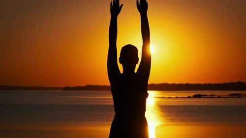 Silhouette of a Young Woman Raises Her Hands Up Against the Sunset Slow Motion