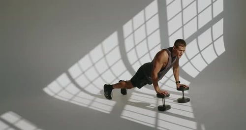 Athletic Young Man Performing PushUps in Studio Environment