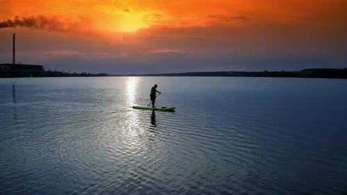 Paddle Boarding on Lake at Sunset