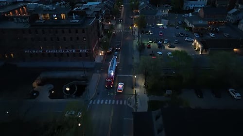 Coche de policía en la calle principal de American Town por la noche. Vista panorámica con inclinación aérea hacia arriba. Establecimiento de Zumbido sc