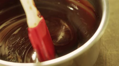 Mélange de chocolat liquide à la spatule au ralenti pour une préparation de desserts savoureux