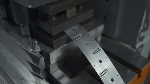 A large industrial punch press forming sheet metal parts. Creative. Close up of sheet metal stamping
