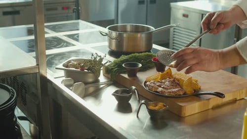 Chef Plates Steak and Potatoes in Kitchen