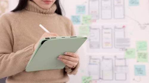 Conception utilisateur pour femme, tablette et interface utilisateur, le développeur étant créatif pour un projet d'Appli mobile avec un stylo