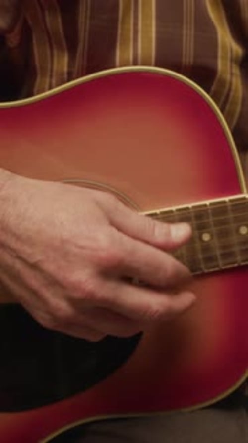 Senior Man Plays Acoustic Guitar in Living Room