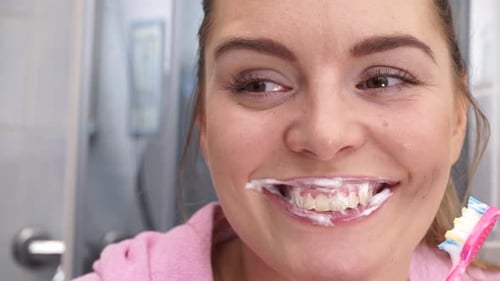 Woman Brushing Teeth in Bathroom Close Up