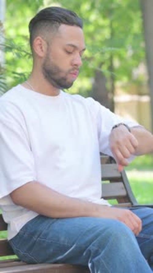 Vídeo vertical, homem de meia idade sentado ao ar livre saindo do banco