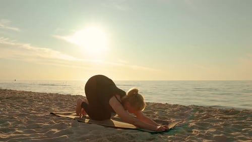 Calm Middle Years Woman Practicing Yoga at Sea Girl Making Stretching Oriental Pose on Fitness Mat