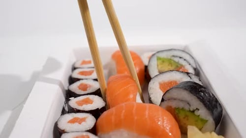 Sushi with chopsticks in foreground.