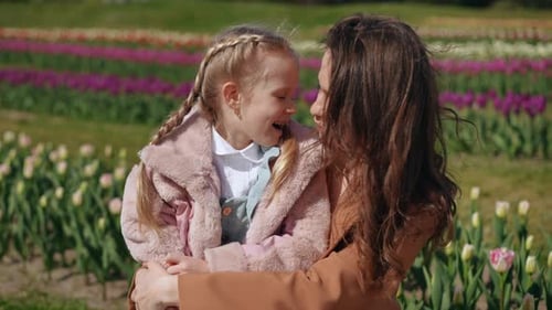 Delightful Moments Shared Between a Caring Mother and Her Daughter Amidst a Vibrant Tulip Field