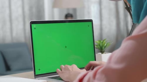 Close Up Of A Muslim Woman's Hands Typing On Mock Up Green Screen Laptop At Home