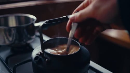 Man Stirring Coffee With A Spoon On The Kettle. - closeup shot