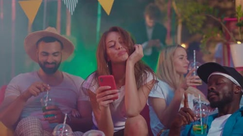 Jovens amigos em uma festa equilibrando socialização e conectividade