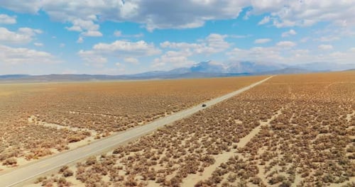 Long straight road in the lifeless desert. Highway to Nevada from California.