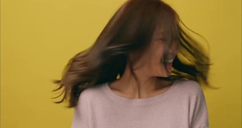 Smiling Woman Shakes Her Head on Yellow Background