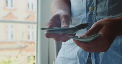 Adult Counts Cash, Rolls it Up, Puts in Pocket