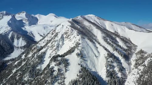 Air flight through mountain clouds over beautiful snow-capped peaks of mountains and glaciers.