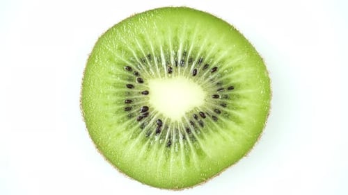 Rotating Fresh Kiwi Slice On A White Background.