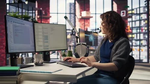 Mujer joven en la oficina mirando la interfaz de usuario en la pantalla del PC y ejecutando código binario