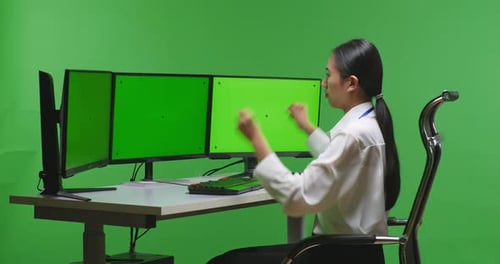 Happy Asian Woman Celebrating While Working With Mock Up Multiple Computer Monitor In Green Screen