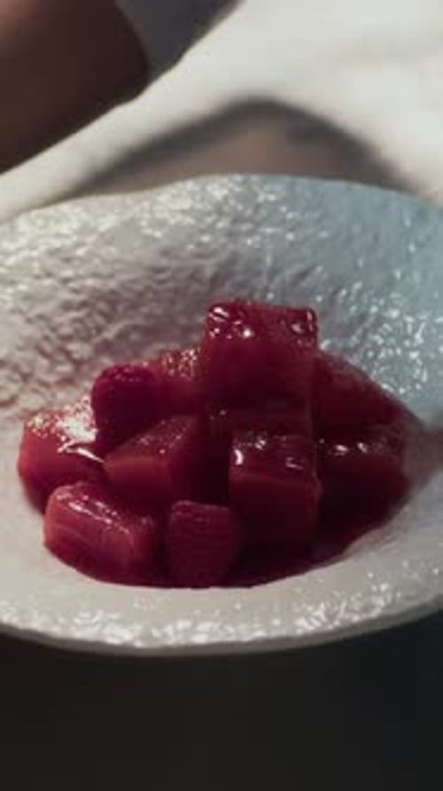 Hands of Cook Using Chopsticks to Plate Tuna Cubes before Serving in Restaurant