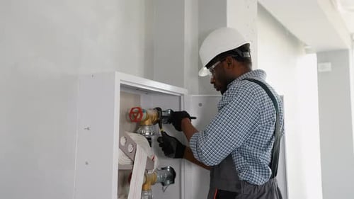 Plumber Using Wrench While Installing Fire Hydrant in Office