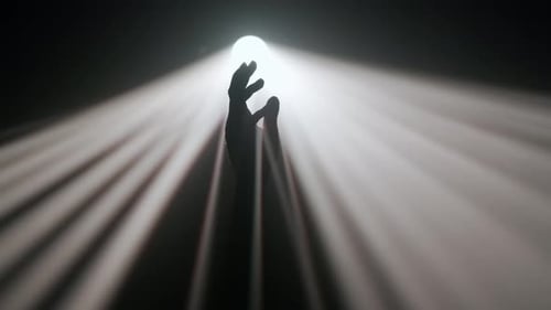 Heller, warmer Strahler, professionelle Lichtausrüstung, die sich in der Dunkelheit dreht, Hand, Silhouette, Berührung