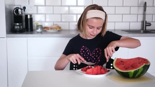 Mädchen schneidet und isst Wassermelone