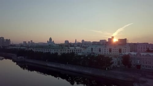 Sunrise Over Urban Cityscape with River Reflection