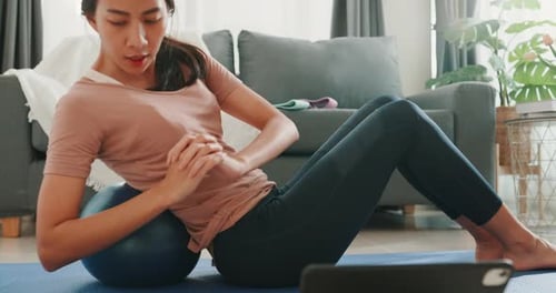 Woman Doing Sit-Ups on Ball at Home