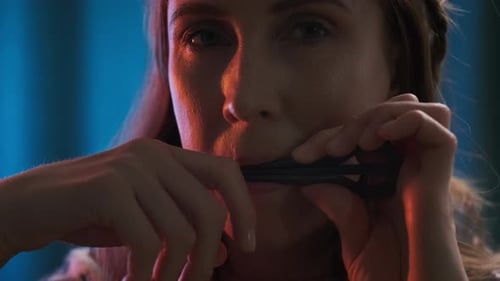 Jaw harp player. Portrait of the young woman in authentic clothes playing jaw harp. Extreme close up