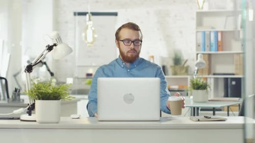 Man Types on Laptop in Bright Modern Office