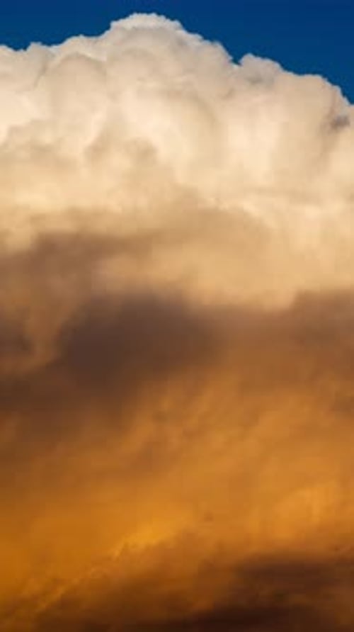 Golden Hour Clouds Against Deep Blue Sky, Vertical