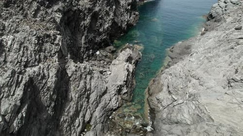 (Top down view) Aerial view drone over sea cliff with powerful sea waves. Beach sand in Sardinia, It