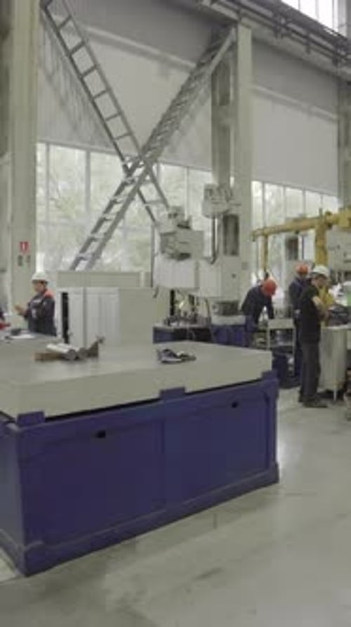 Factory Workers Assembling Industrial Parts on a Machine Stock Clip