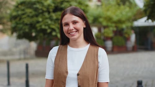 Portrait of Smiling Brunette Young Woman Friendly Glad Expression Looking at Camera on City Street