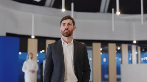 Young Handsome Entrepreneur Walking Confident Along Business Center Modern Hall with Corporate