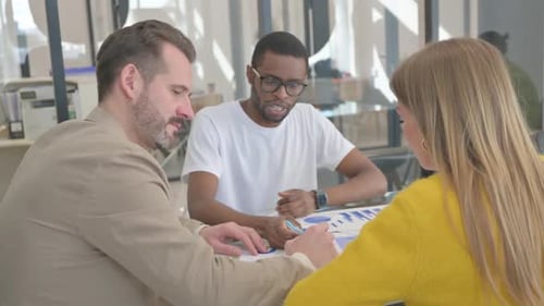 Business Team Analyzing Charts Together in Modern Workplace