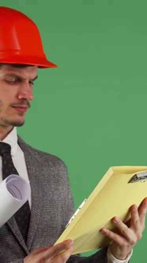 Perplexed Bearded Male Engineer in Hardhat Reviewing Construction Documents
