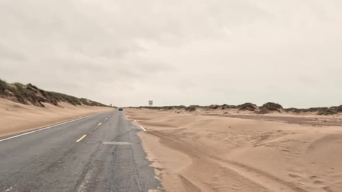 POV Wide View of Car Drive on Road in Desert During Sand