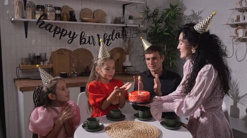 Happy Family Celebrates Birthday with Cake in Kitchen