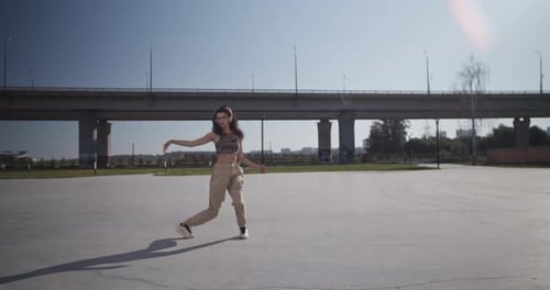 Young Woman Dancing on Sunlit Street