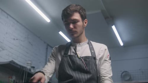 Young Chef Cooking Food in Frying Pan