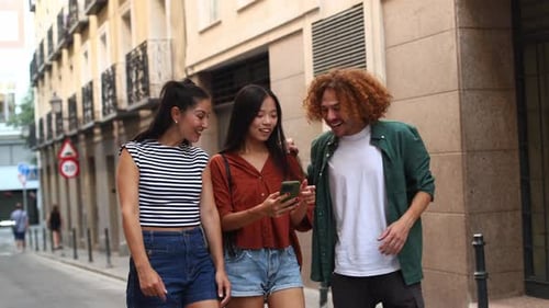 Young Tourists Navigating City with Smartphone and Sharing Laughter