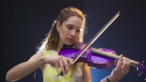 Young Woman Plays Bright Purple Violin Artistically
