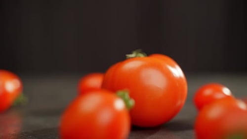 Hay un gran tomate rojo sobre la mesa al que los más pequeños ruedan