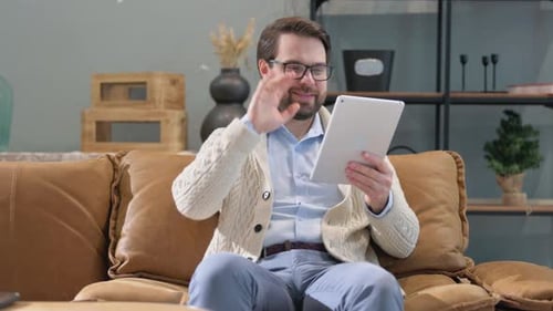 Man Uses Tablet for Video Call at Home