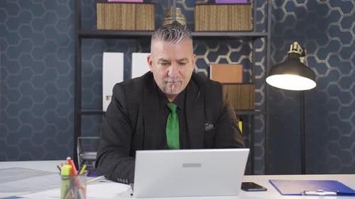 Adult Man Typing on Laptop in Office